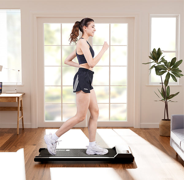 Woman walking on a Deerrun walking pad in a bright home living room